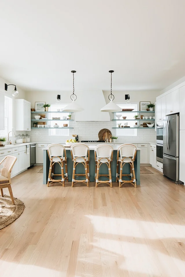 The kitchen keeps the same color scheme as the rest of the house, with a slightly darker shade of aqua on the island, anchoring it a bit and setting it apart from the white of the rest of the kitchen.