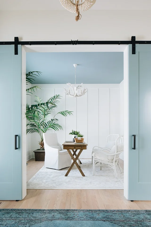 The blue here is continued upward into the ceiling to reflect a blue sky, bringing the outdoors in, while the rug below is a soft white.