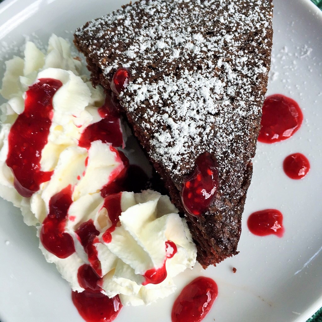 Strawberry sauce on whipped cream with chocolate almond cake