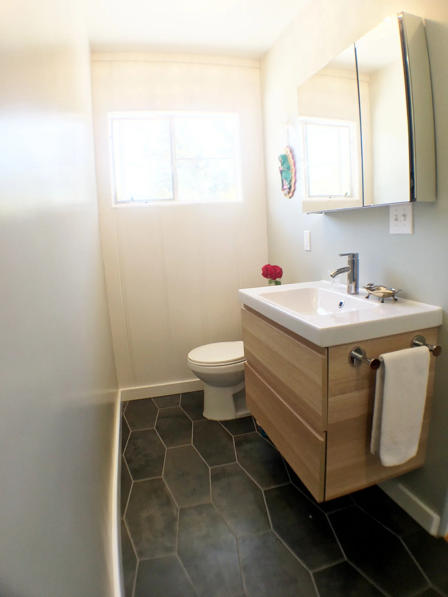 The vanity and toilet needed to trade places because it seemed strange to walk into the bathroom and walk past the toilet to get to the vanity. Somehow this opened things up a bit which enabled us to get a larger vanity. 