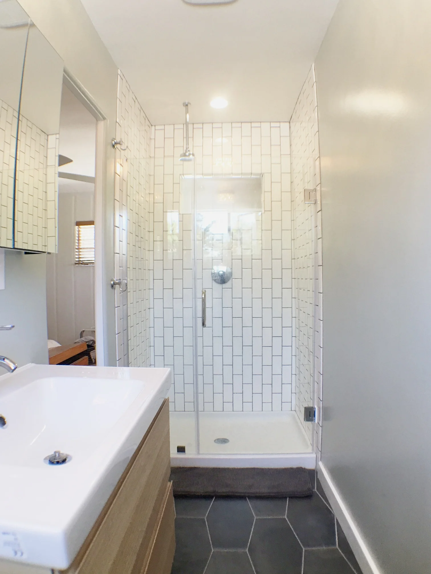 Drum roll, please. Here is my new shower! We did it super basic with white subway tile. Grout is Delorean Gray . We turned them on their sides, just for something different.