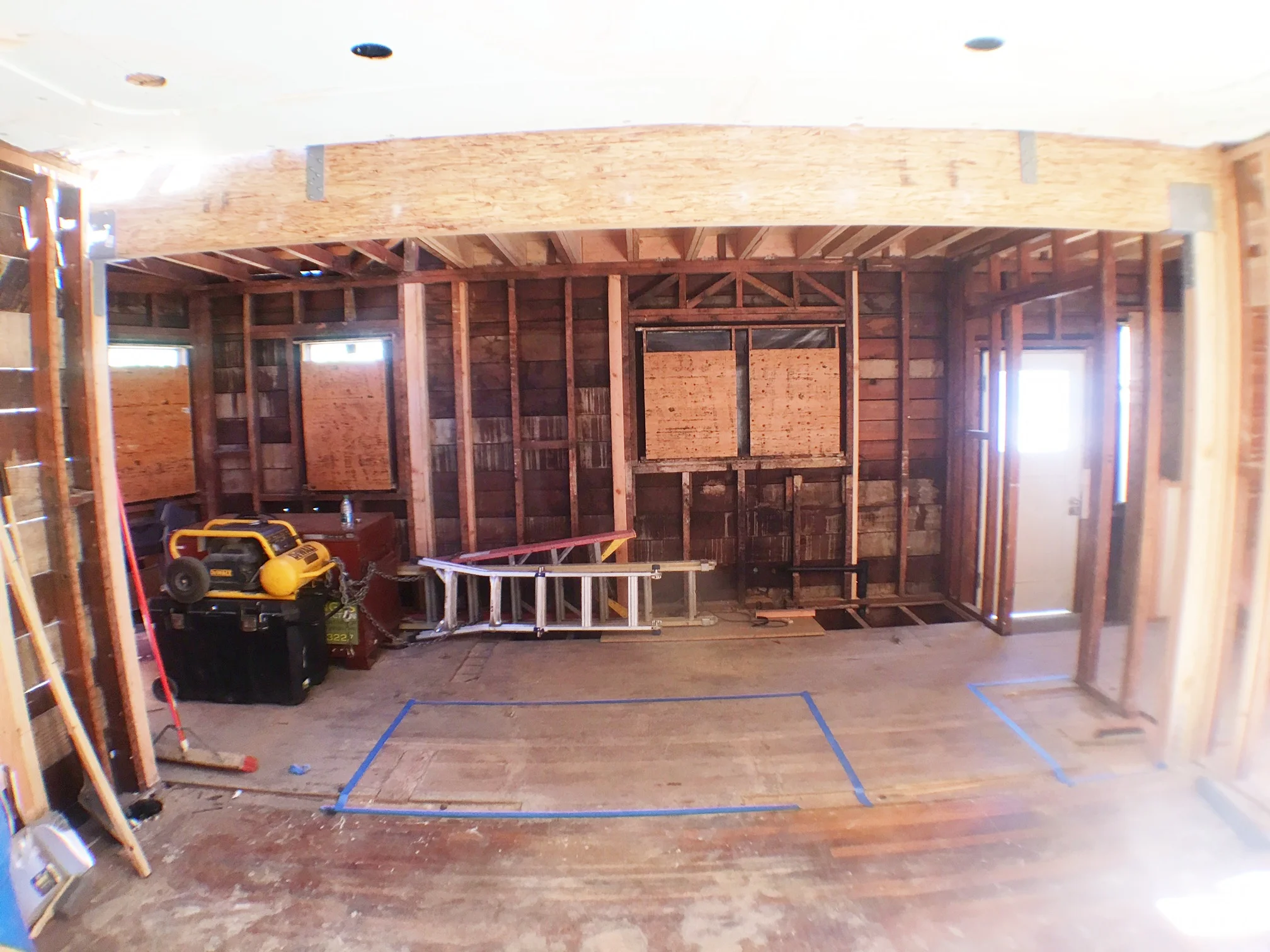 Now that the walls are opened up and headers are in, we are taping off the area (see blue tape) to look at where the cabinets, fridge and 7-ft island!!! will go.