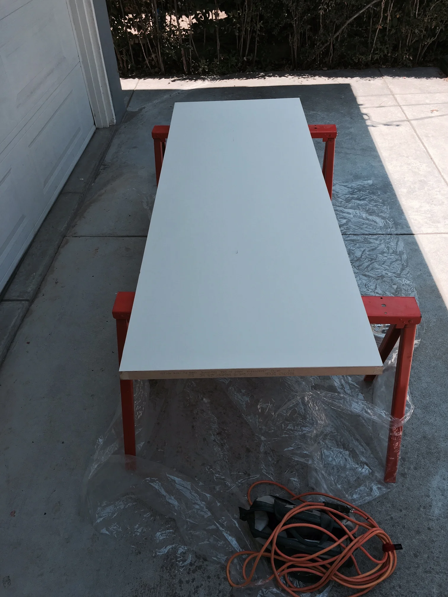 The easiest way to paint or sand any object is to raise it onto a table. I used these portable saw horses and tried to keep it in the shade.