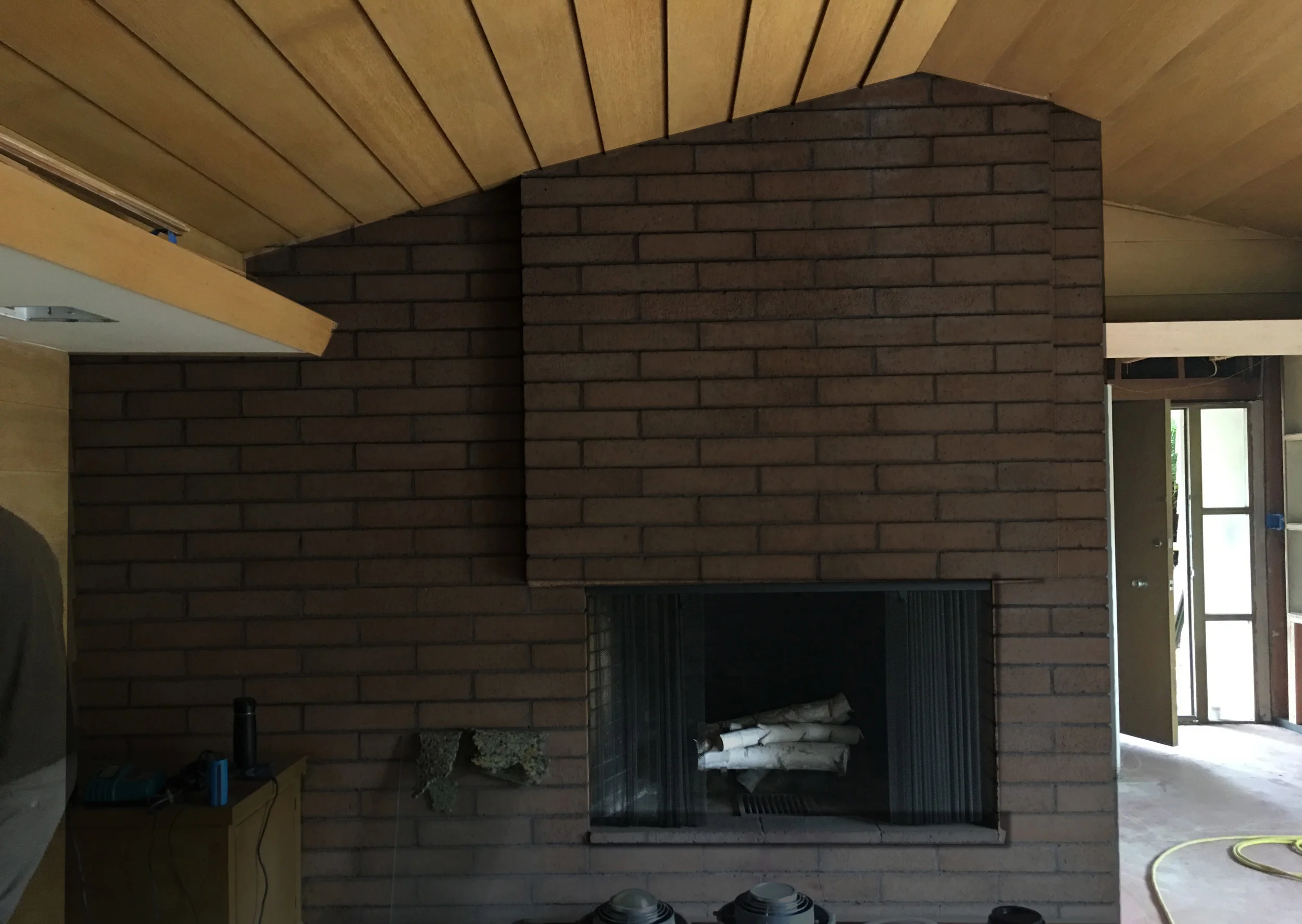 My thoughts: I've always liked the look of painted brick. I would probably choose Chelsea Gray (since I am somewhat obsessed) and do it in a satin finish. I think it would pair nicely with the wood paneling throughout the room. And someone could hang some fabulous mid century modern mirror on it.