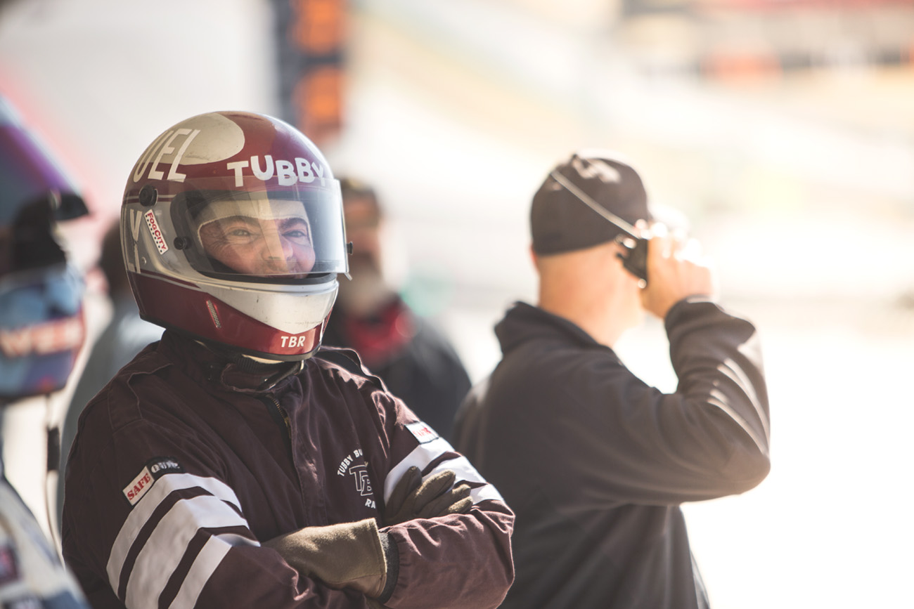 Teammates listen to the radio and watch for their car to round the corner, safe, still in the race, still a chance to win.