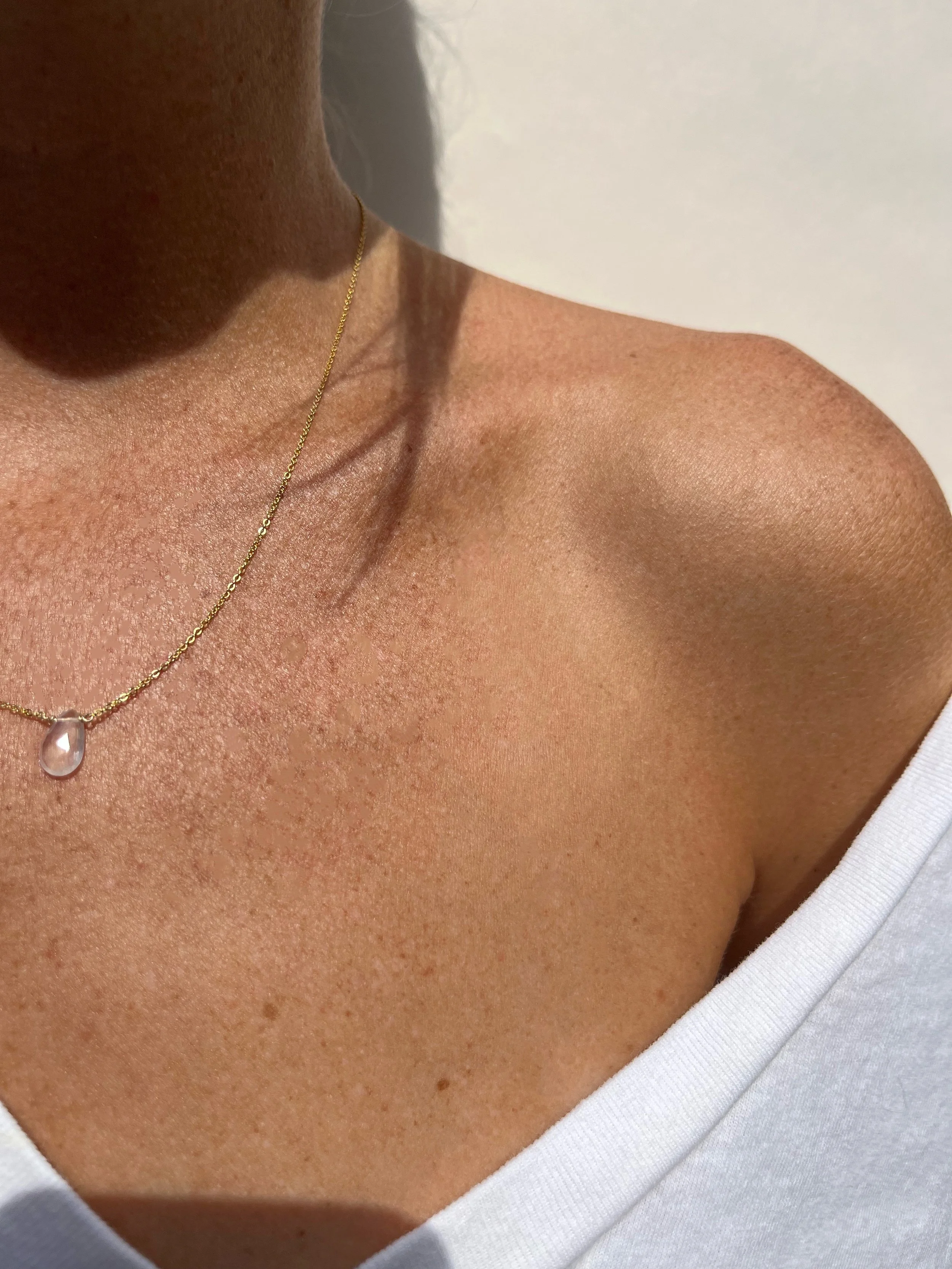 Woman wearing rose quartz drop necklace | handmade minimalist jewelry | THALKEN