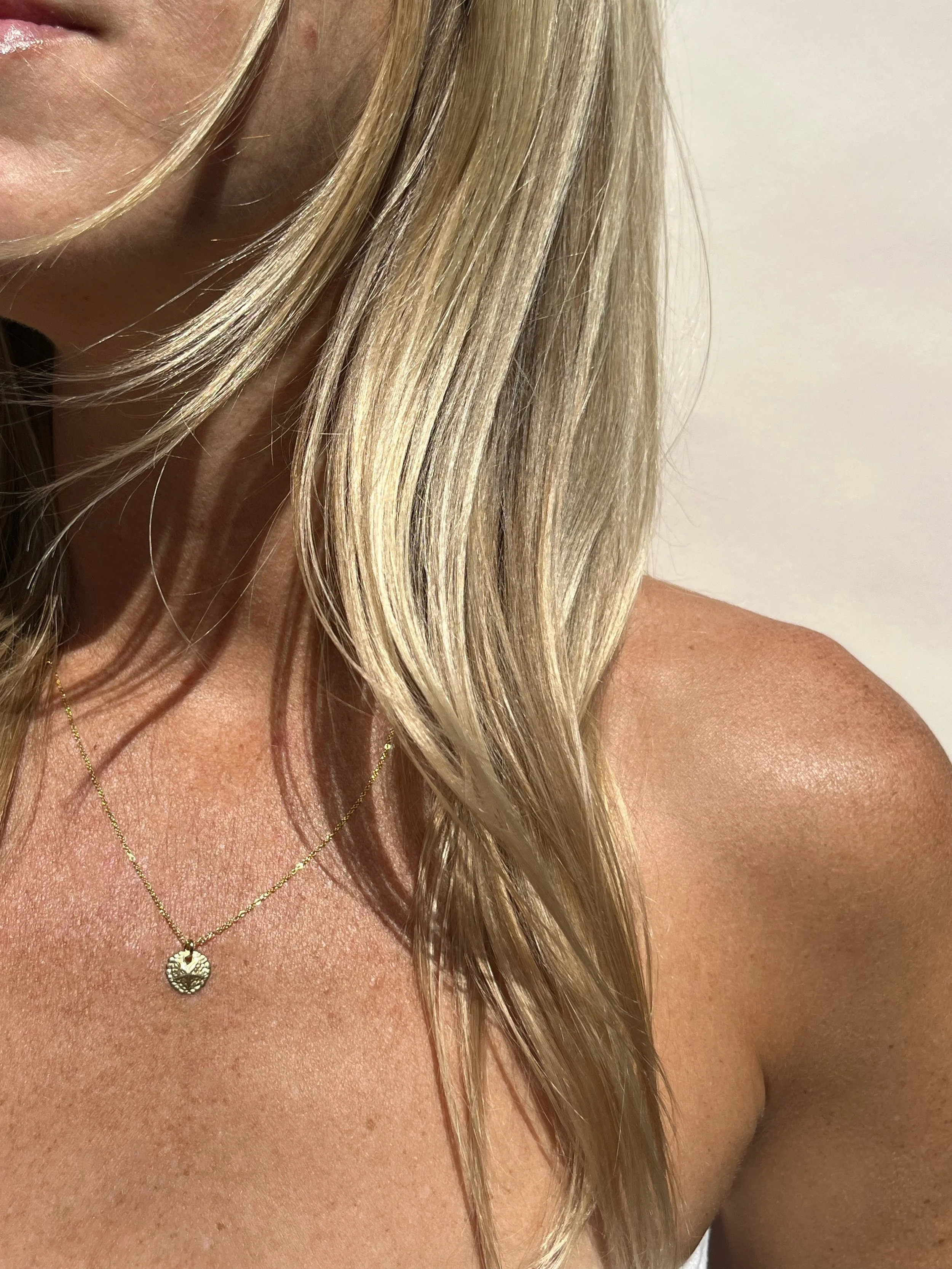 woman wearing gold sand dollar charm necklace | handmade lafayette jewelry | THALKEN