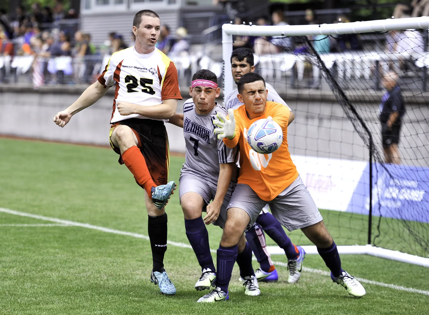 Team Maryland player attempts to score and Team Florida goalkeeper deflects the ball on the Championship Field of the University of Seattle.