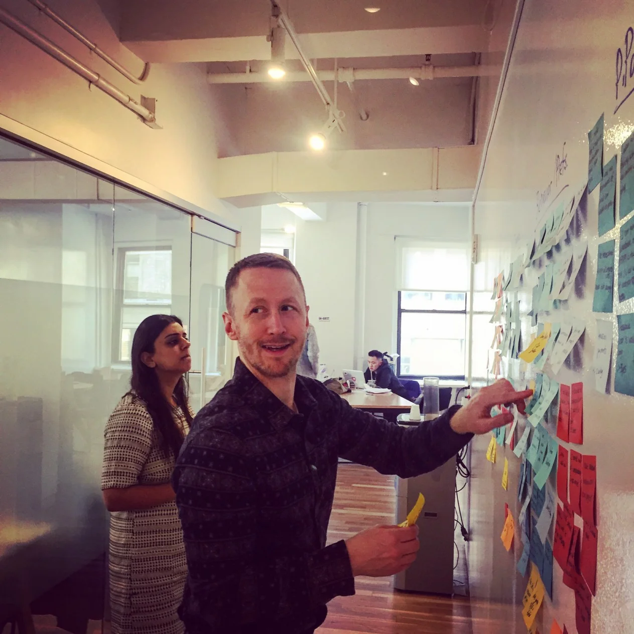 Andrew and Bani look for patterns in the insights during our affinity mapping synthesis.