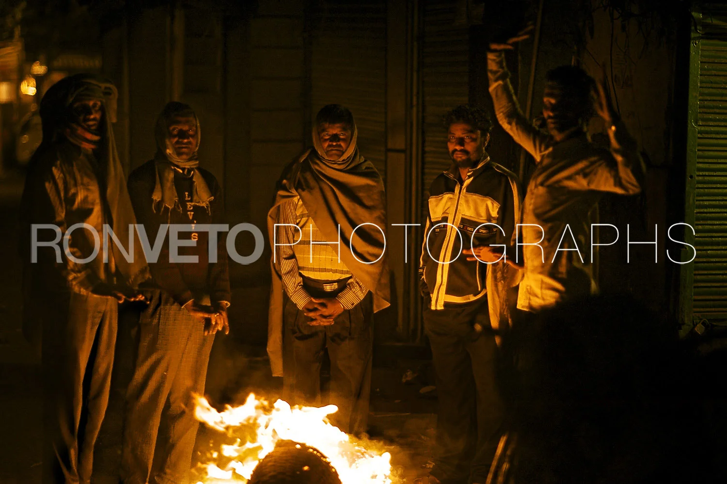 Men by firepit, Agra, India
