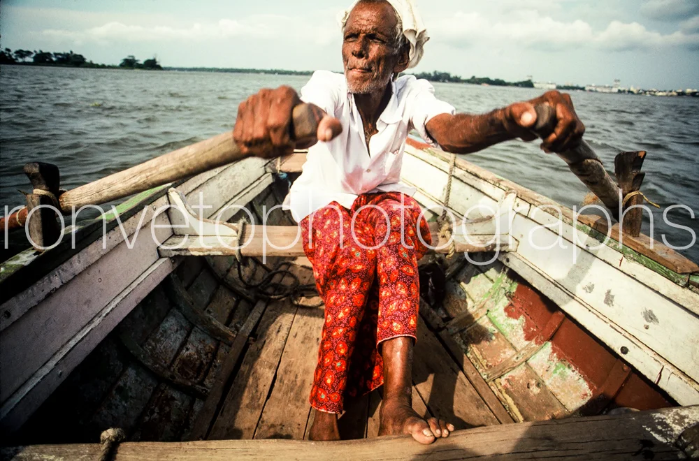 Old man rowing, India