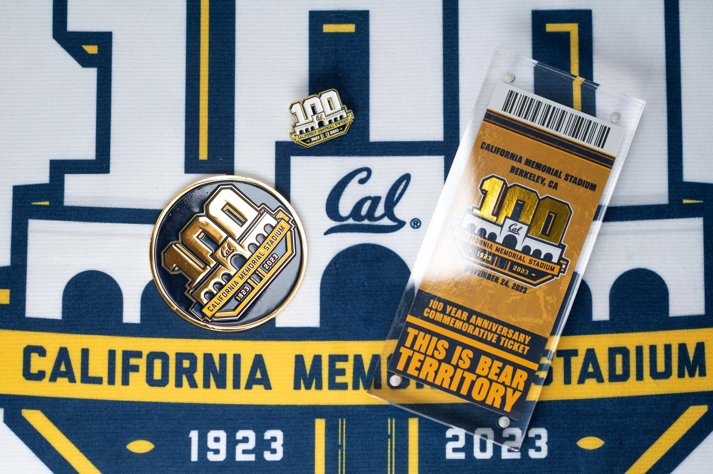 Cal logo, commemorative pin, and ticket celebrating California Memorial Stadium's 100th anniversary at Berkeley, CA, with the date December 24, 2023.