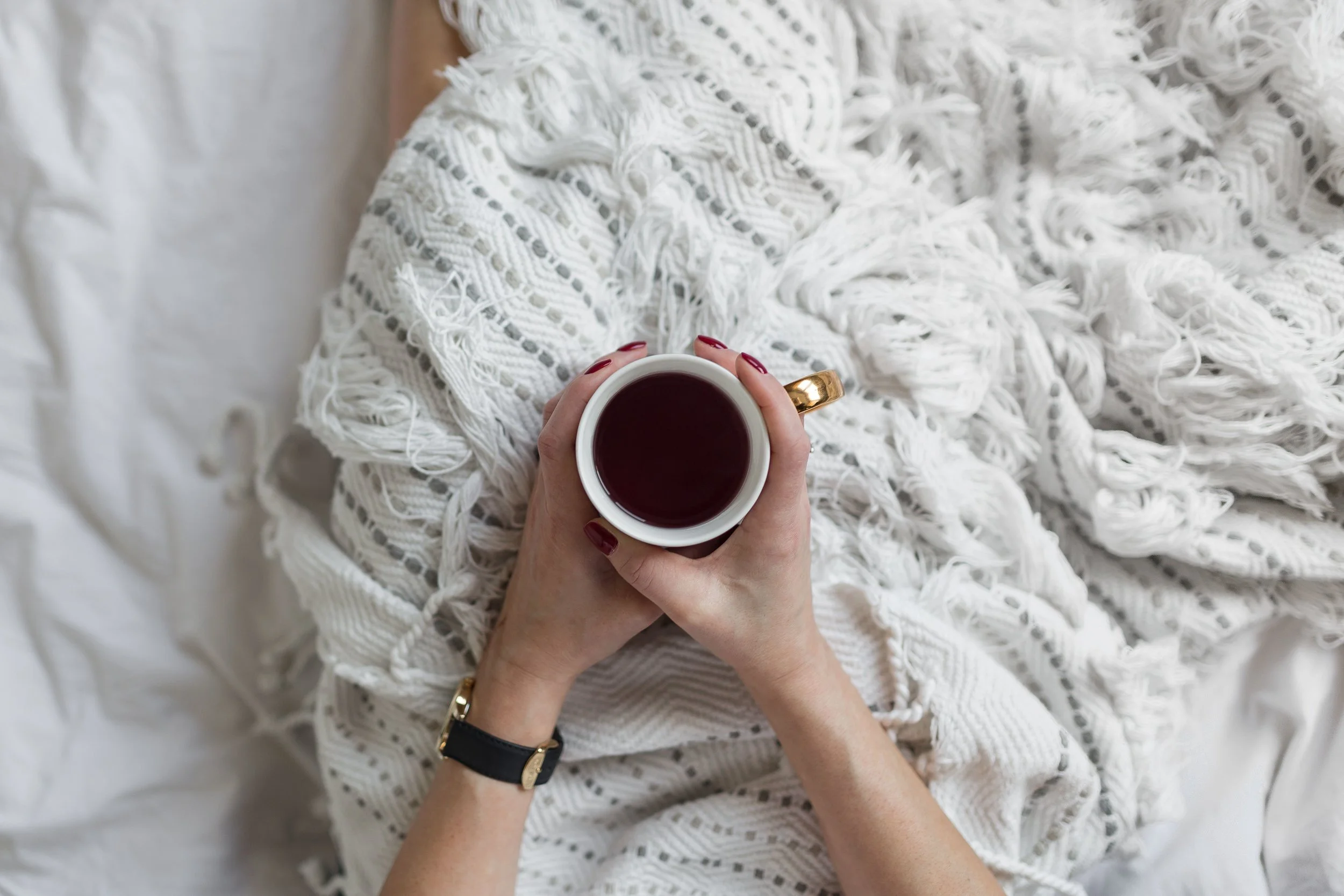 kaboompics_Soft photo of woman on the bed with the book and cup of tea in hands.jpg