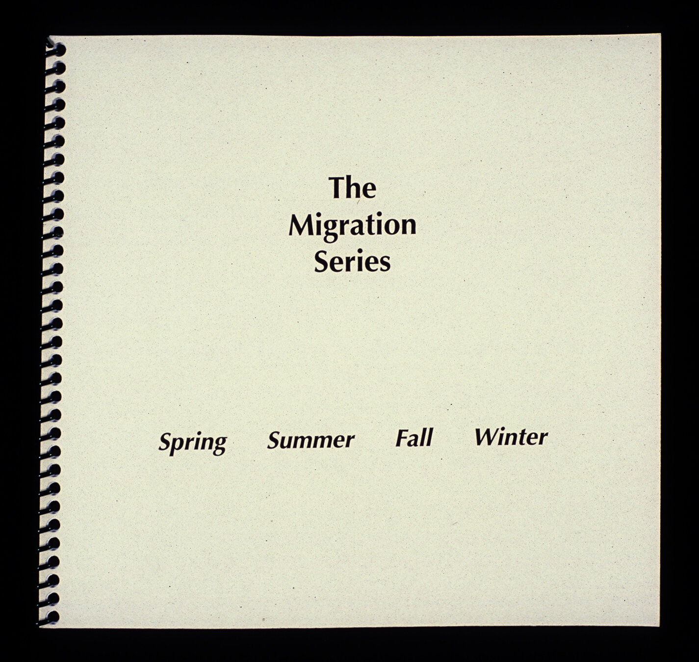 White cover of square spiral bound book with black text reading “The Migration Series, Spring Summer Fall Winter.”