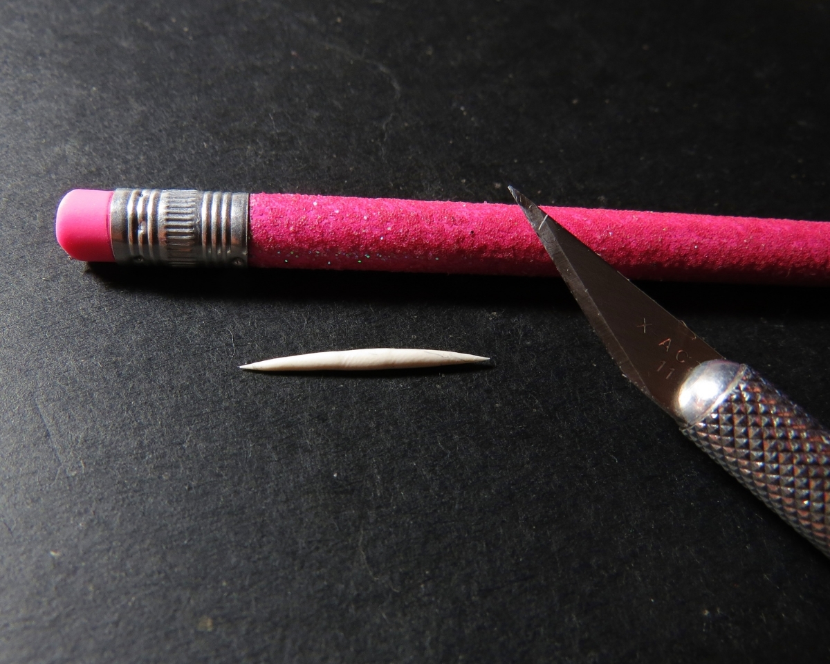 2. It's time to make some claws from Sculpey . Roll out a tiny slug shape like so. Try to avoid leaving fingerprints on the roll.