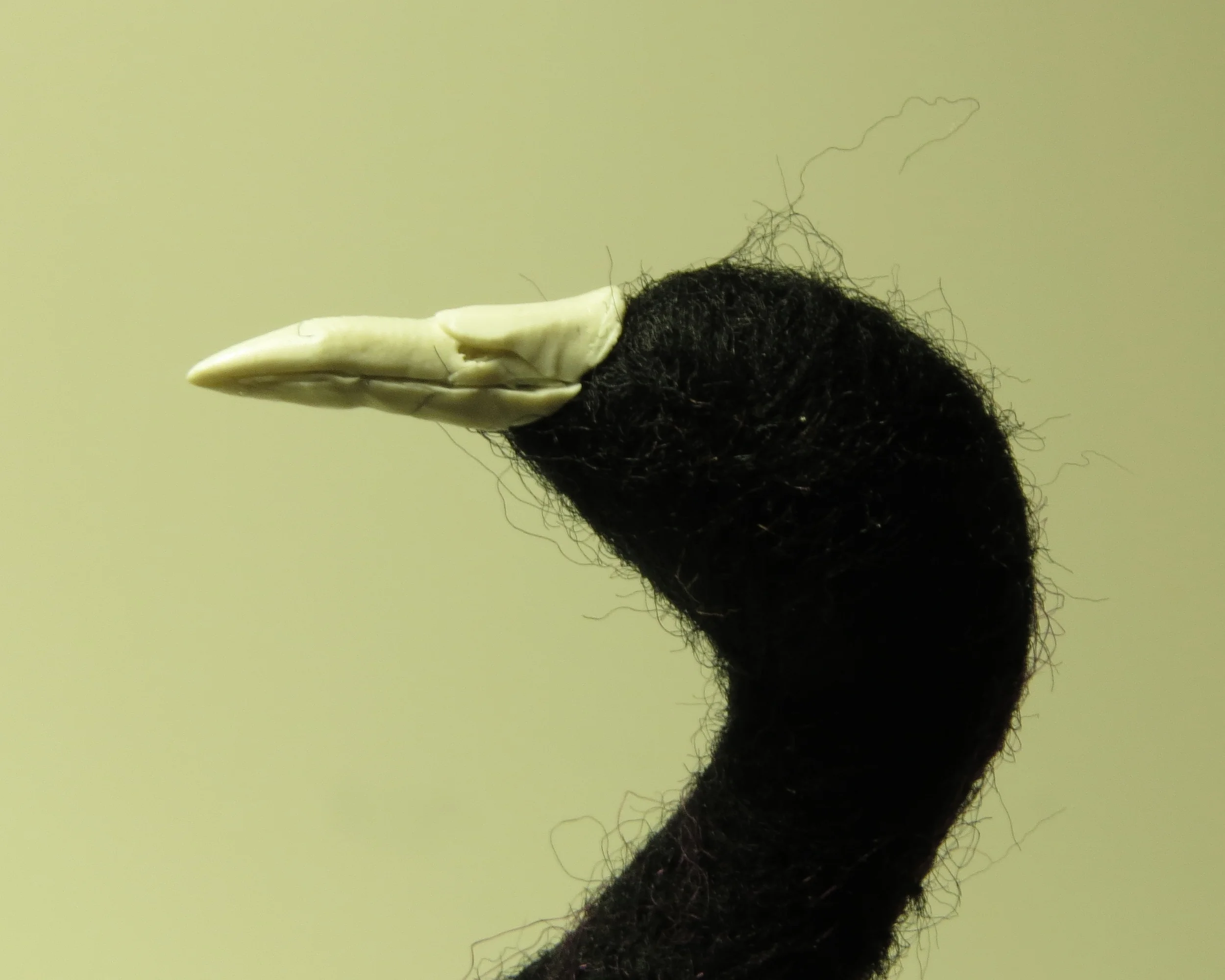 14. Keep working on the beak with a tool until it pleases you. Try to keep the wool out of the Sculpey. Make nostril holes with the tip of your blade or with a needle.