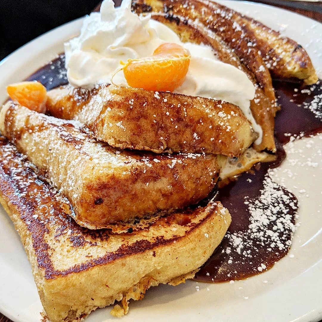 Flan French Toast: Dipped in flan mixture & served w/caramel sauce, whipped cream & fruit.