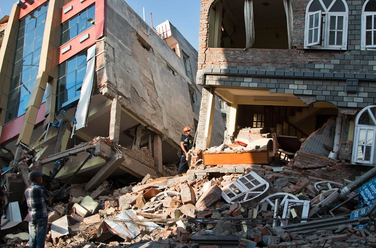 A rescue worker stands beside buildings that collapsed in an earthquake in Kathmandu, Nepal.