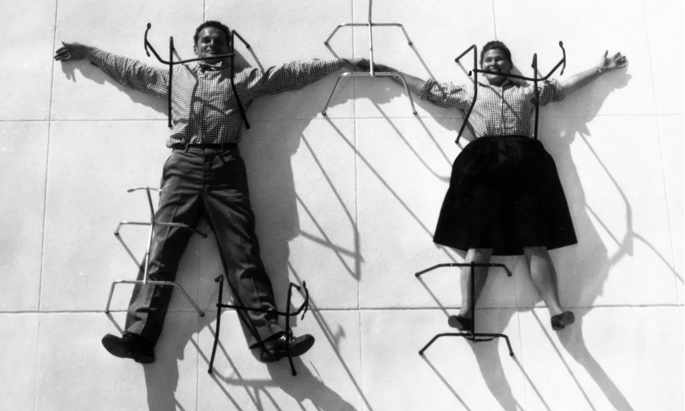 Charles and Ray Eames, posing with their chair bases. Photograph: Eames Office