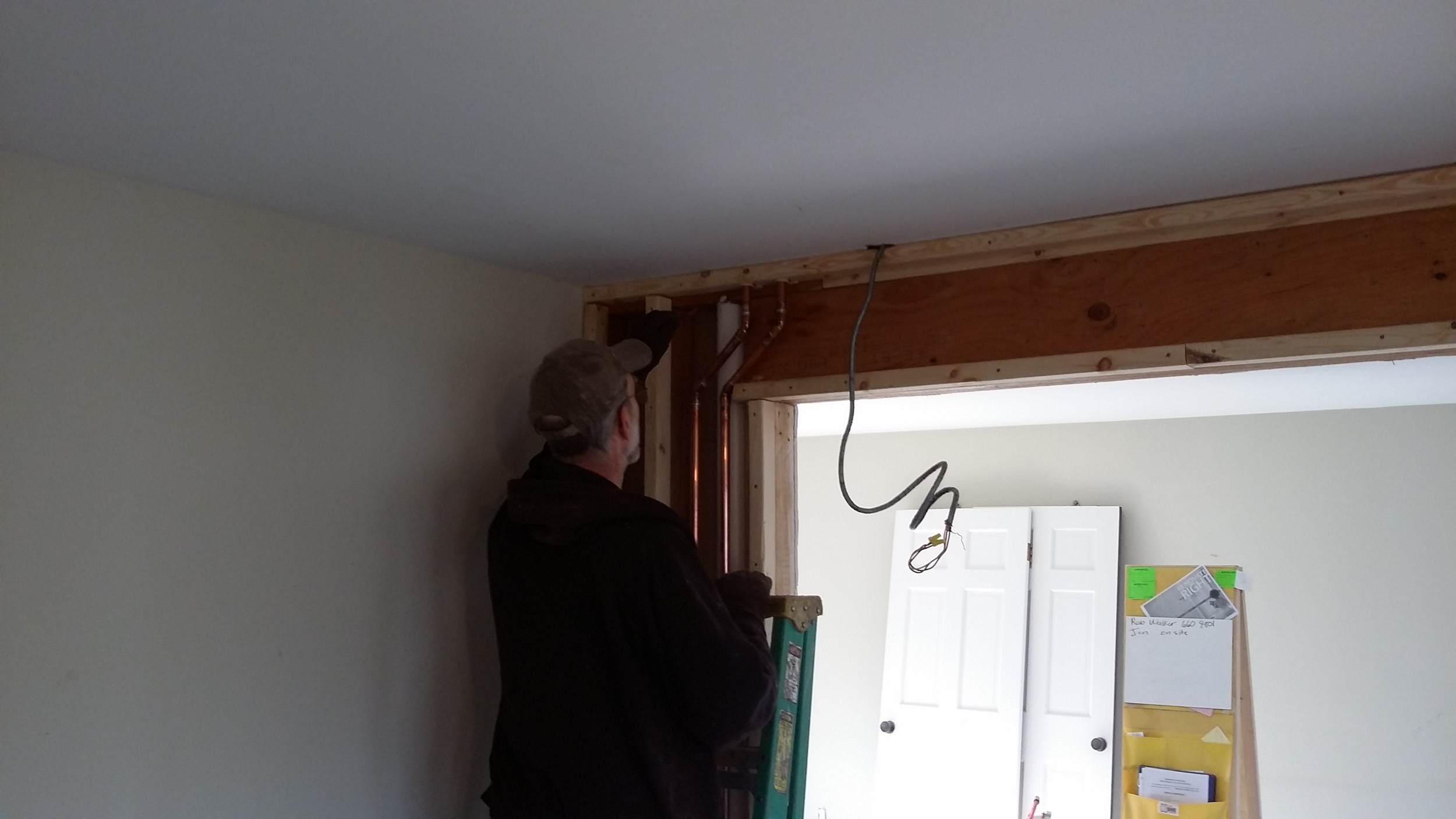 Randy our plumber, working through a more subtle change to the plumbing. &nbsp;To enlarge the doorway to the living room, we moved the plumbing drain and supply over two stud bays. &nbsp;Randy is finishing up his reinstall after the opening was enla…