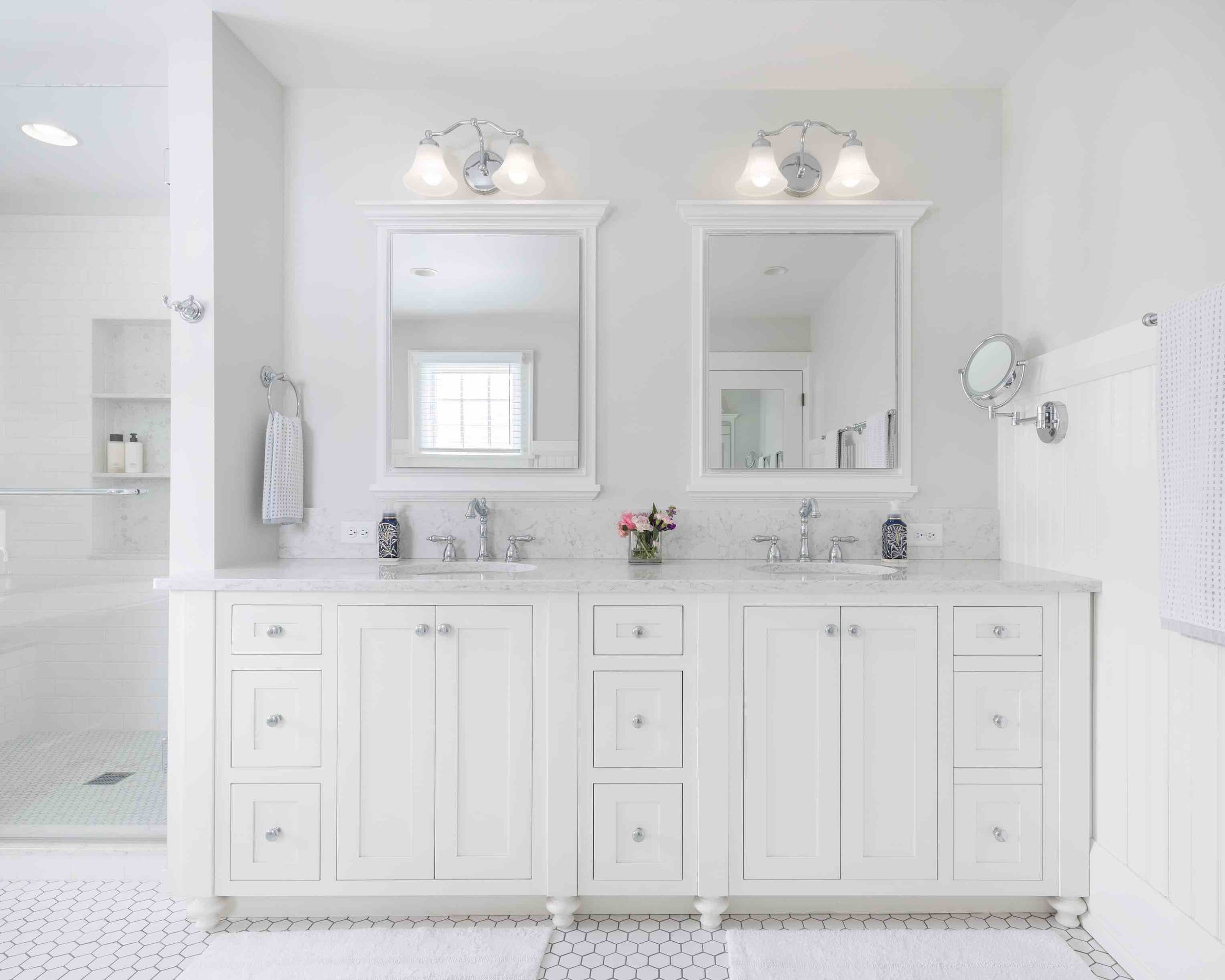 Bright white bathroom with double vaniety with white cabinetry and walk-in shower