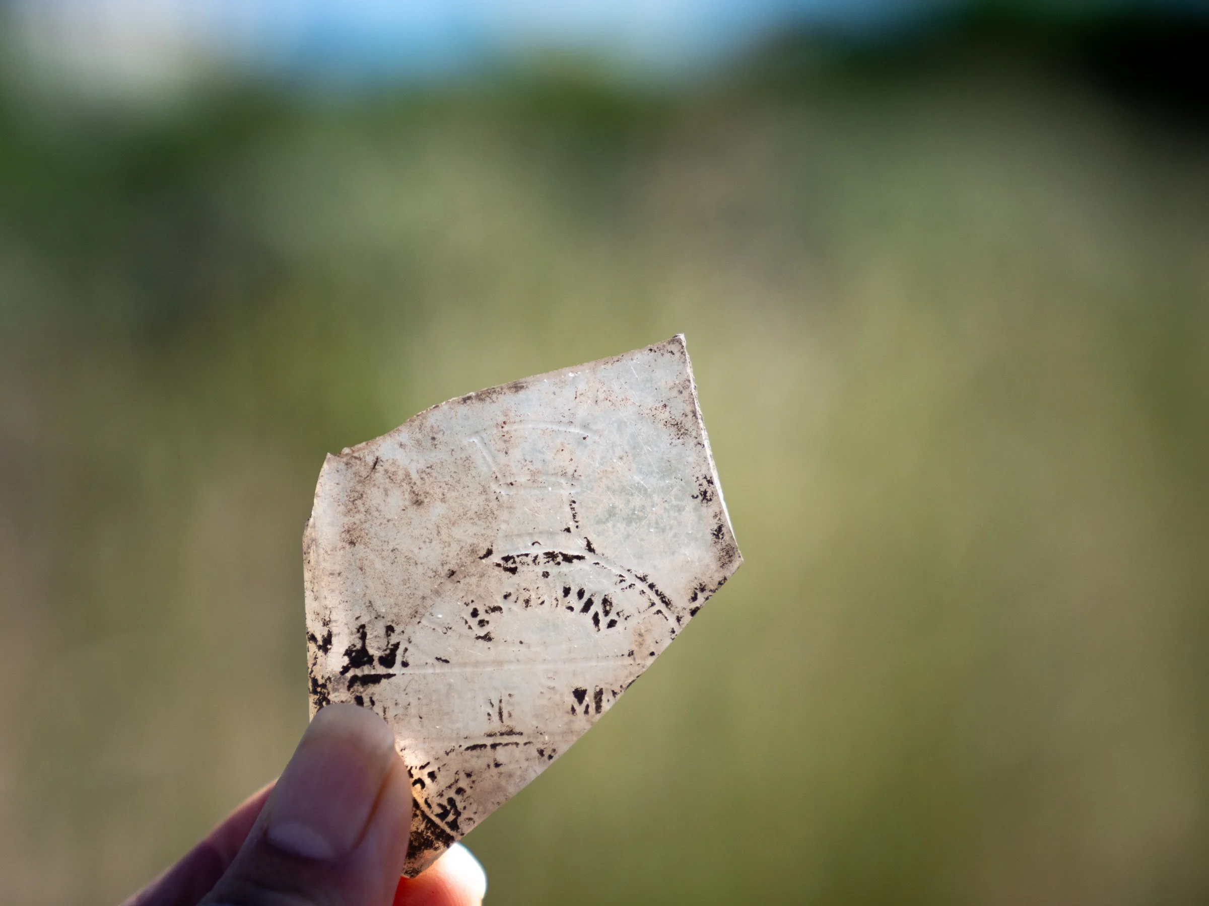 Laura Ng holds a piece of glass excavated at the Evanston Chinatown in a location archaeologists believe to be the laundry site in June 2024.