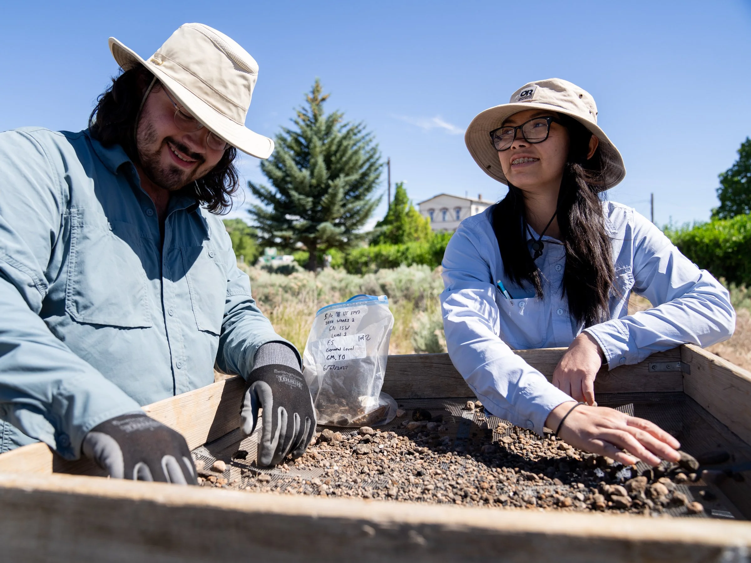 Co-Field Director Laura Ng and student archaeology volunteer George Matthes of Grinnell College sift through dirt for artifacts at an Evanston excavation in June 2024.