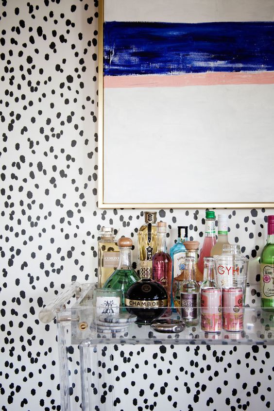 i love that they selected an acrylic bar cart so you can still see the beautiful wallpaper and all the bar accoutrements, via lonny