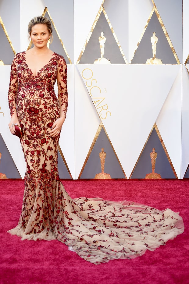 chrissy teigen wearing a baby bump hugging marchesa gown