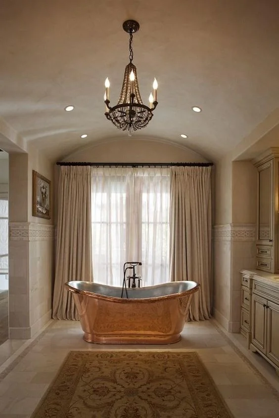 A monochromatic bathroom with the tub pulling the colors of the rug out. 