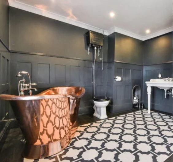 MOODY WAINSCOTTING WITH A GRAPHIC FLOOR AND A POP OF COPPER . 