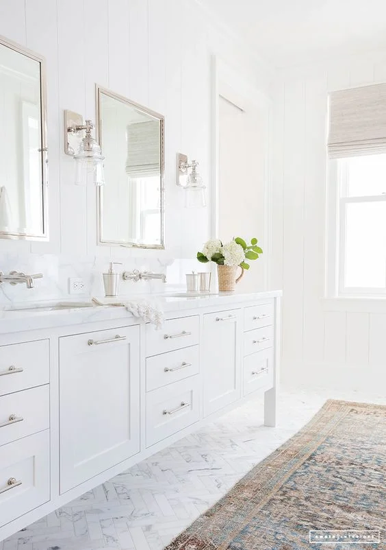 another great way to warm up and give an all white room CHARACTER is by adding a vintage rug. the colors, age, and pattern will add so much to the room. Via Amber Interior Design