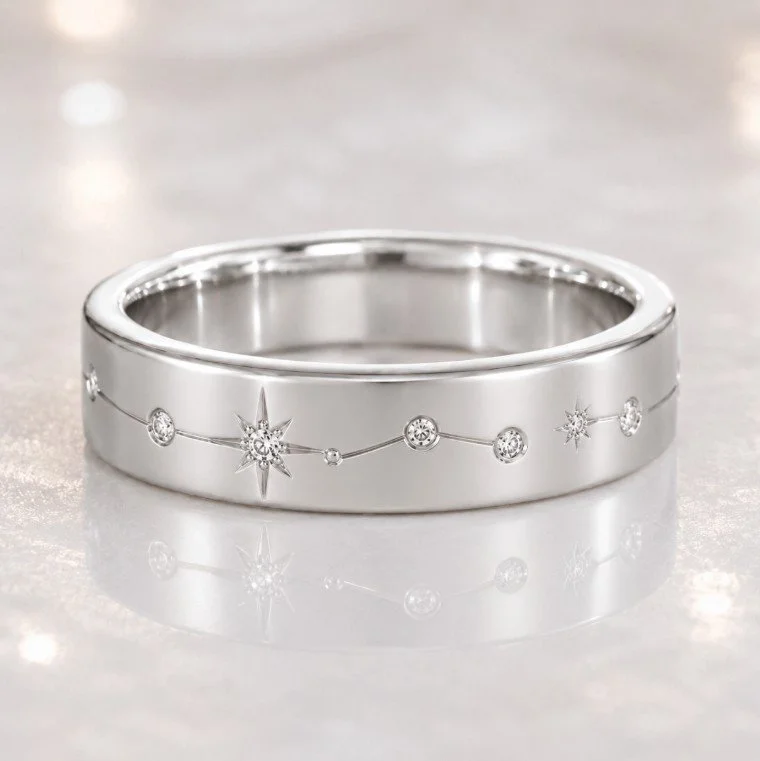 This ring could be 14-karat white gold or Silver  with engraved celestial motifs and small gemstones, resting on a reflective surface