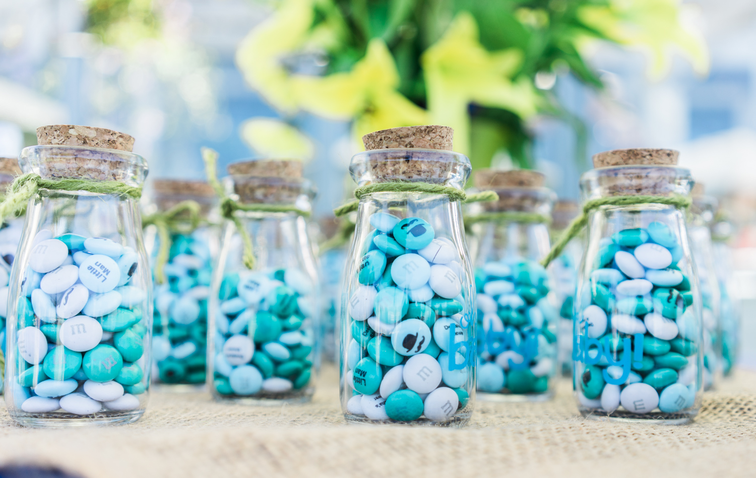 Vintage milk jar bottles filled with moustache engraved m&m's.