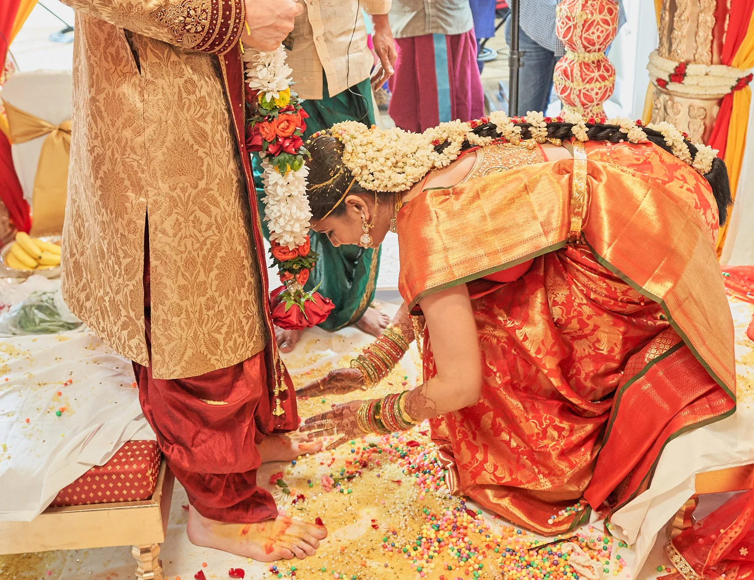 Bride touching her groom’s feet - a sign of love and respect.