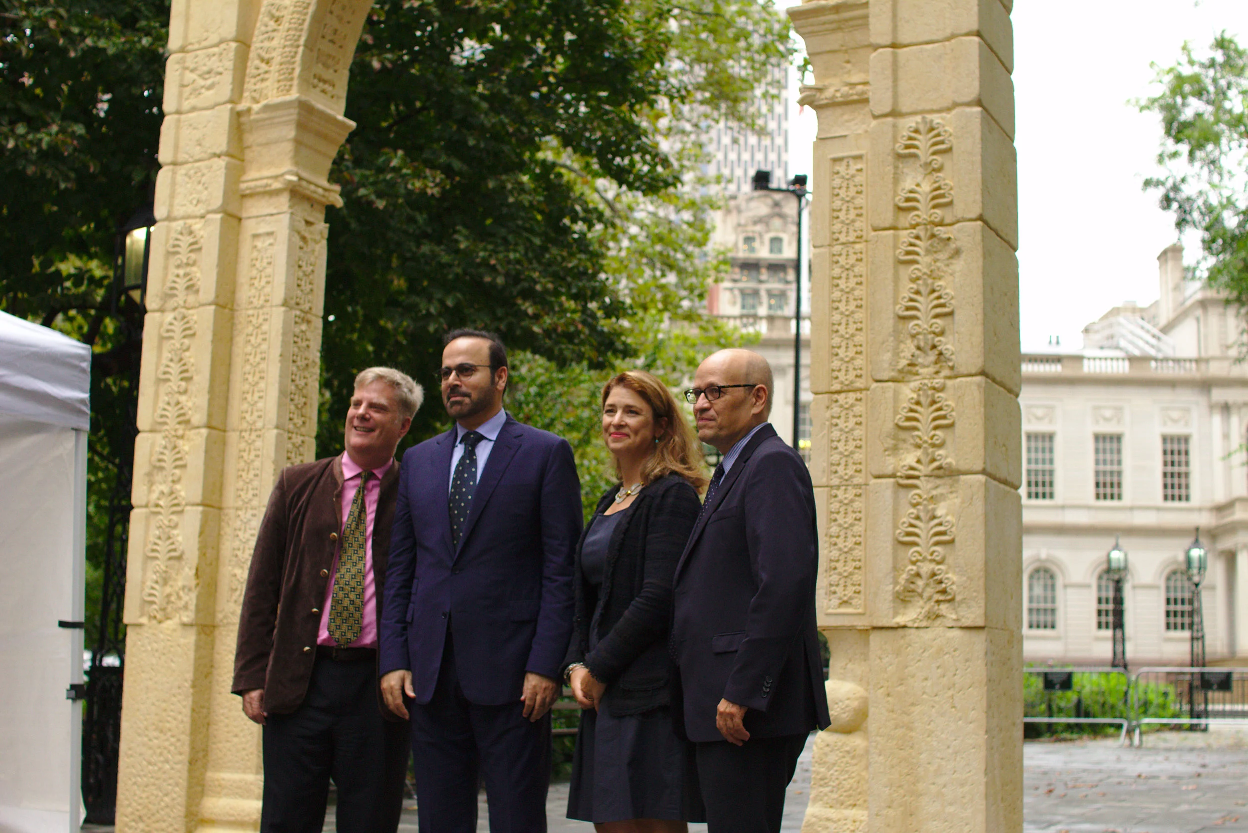 The speakers gather under the Triumphal Arch of Palmyra after its unveiling