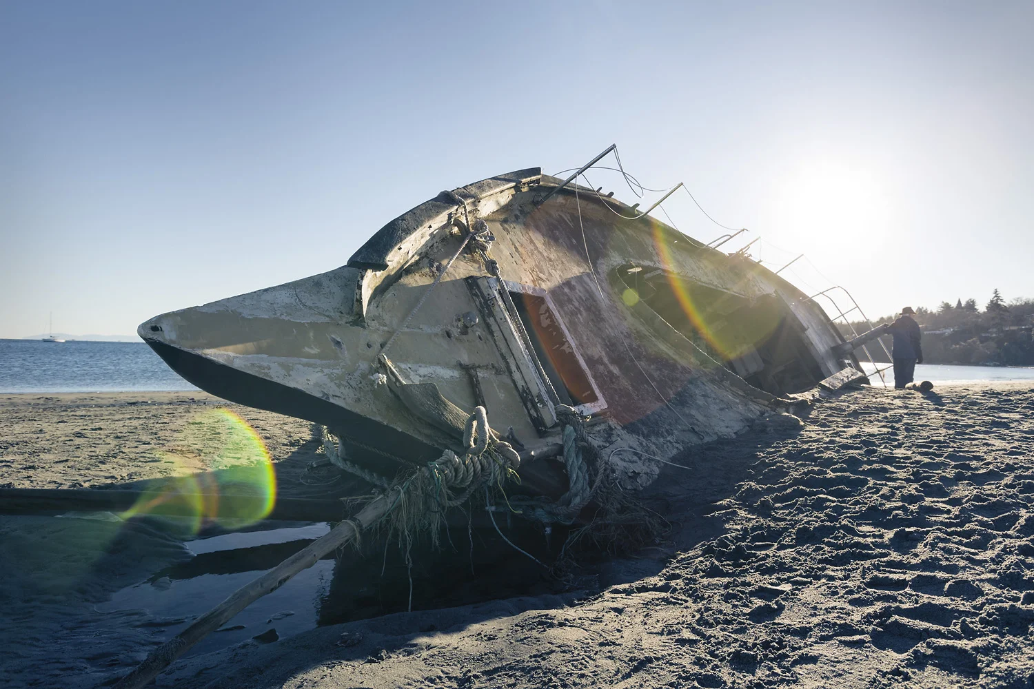 The Pacific Sun King lies partially buried in the sands of Cadboro Bay beach.