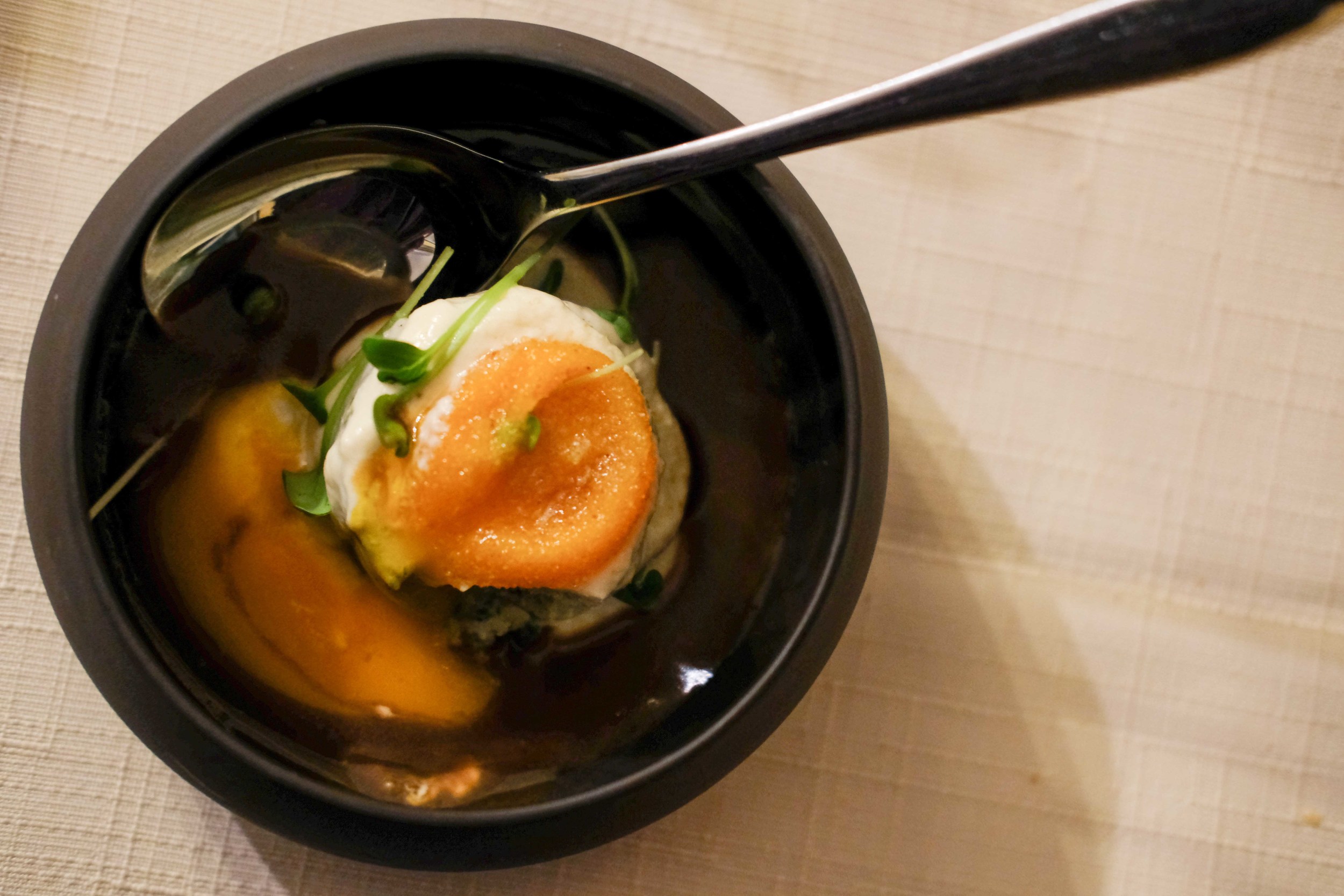 Seminola dumpling with the tips of white hops, reduced beef drippings, topped with a breaded egg yolk and cheese sauce.