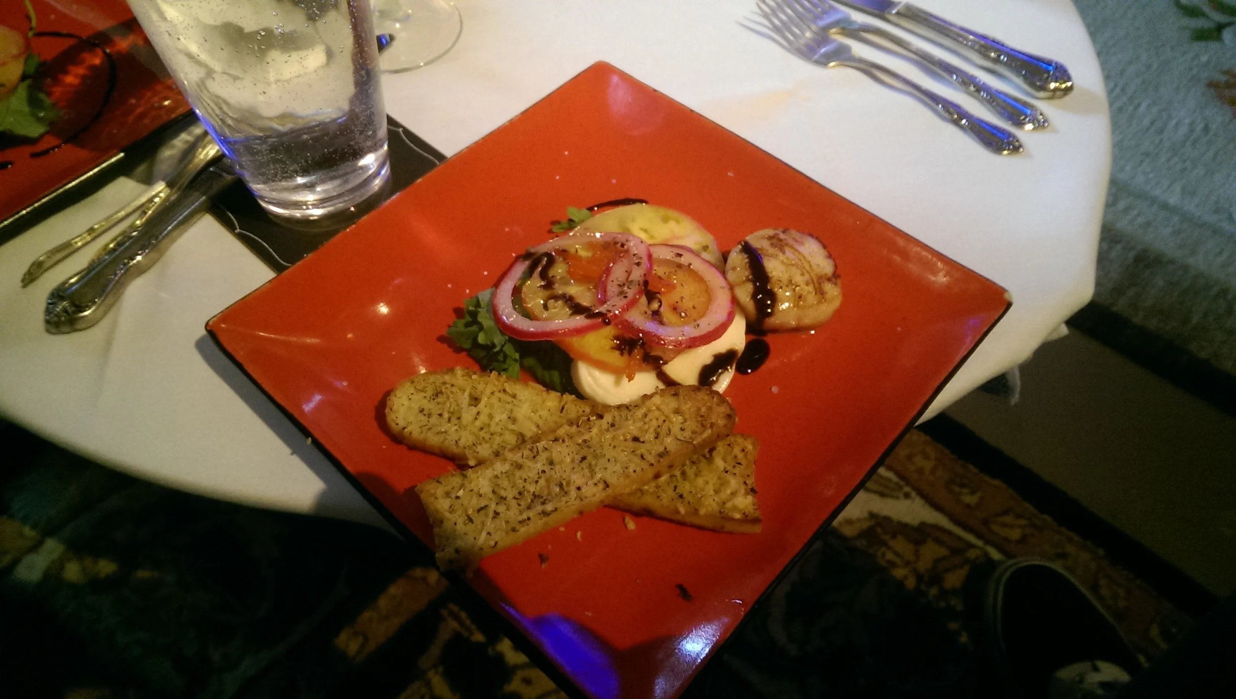 Tomato, Mozzarella, and Baby Greens Salad with Parmesan Crostinis, Seared Scallop, and a Balsamic Reduction 