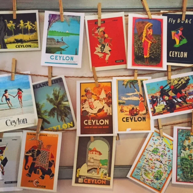 Postcards of old Ceylon travel posters hanging on a wall at The Empire Café in Kandy, Sri Lanka