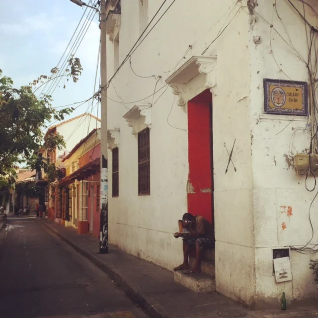 A man reads the paper in his doorstep on a quiet Cartagena morning