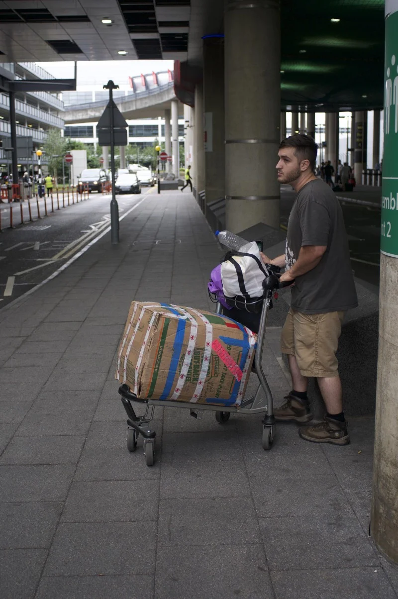 Sad Josiah waiting for our ride with his “suitcase”…yep thats a box and a grocery bag.. I knight thee Josiah the Hobo Traveler…