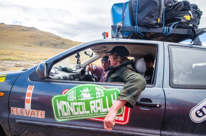 Tom is driving, Mark is in the passenger seat and Jimmy is in the back.