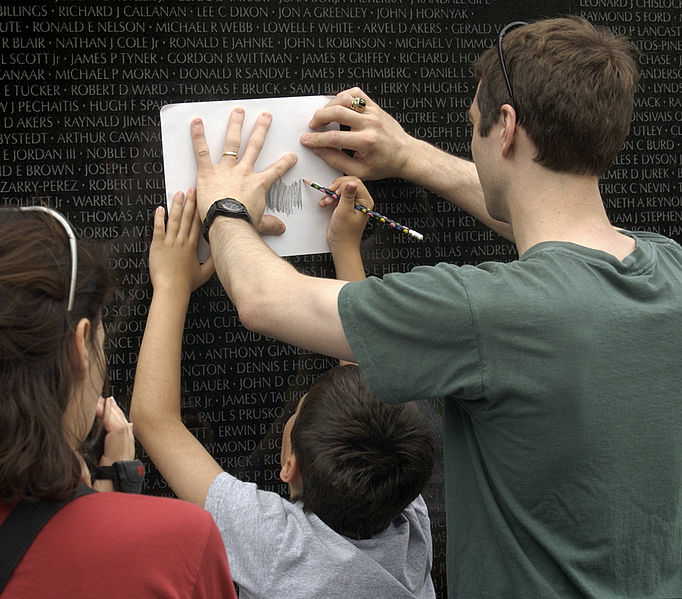 Visitors to the Vietnam Veterans Memorial Wall, take rubbings of the name, of a family member, 16 June 2003. Image source: US Navy 030616-N-9593R-142 Visitors to the Vietnam Veterans Memorial Wall, take rubbings of the name, of a family member.jpg , U.S. Navy photo by Chief Warrant Officer Seth Rossman, licensed under Public Domain Mark 1.0