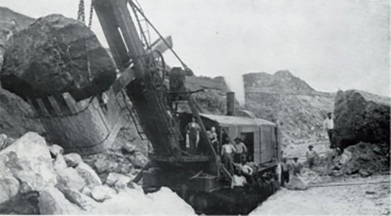 Marion Steam Shovel Model 90, 1908 image showing the shovel at work on the Panama Canal. Image taken from a 1915 Marion Shovel catalog. Image source: MarioModel90 1908.jpg by unknown author is licensed under Public Domain Mark 1.0 in the United States