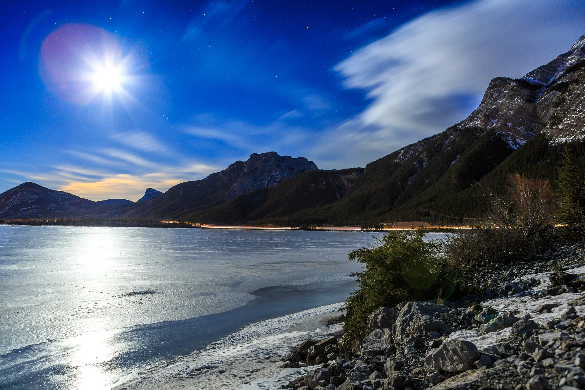 This may look like a bright sun, but it's actually the moon. Taken at night somewhere around Jasper, Alberta, Canada