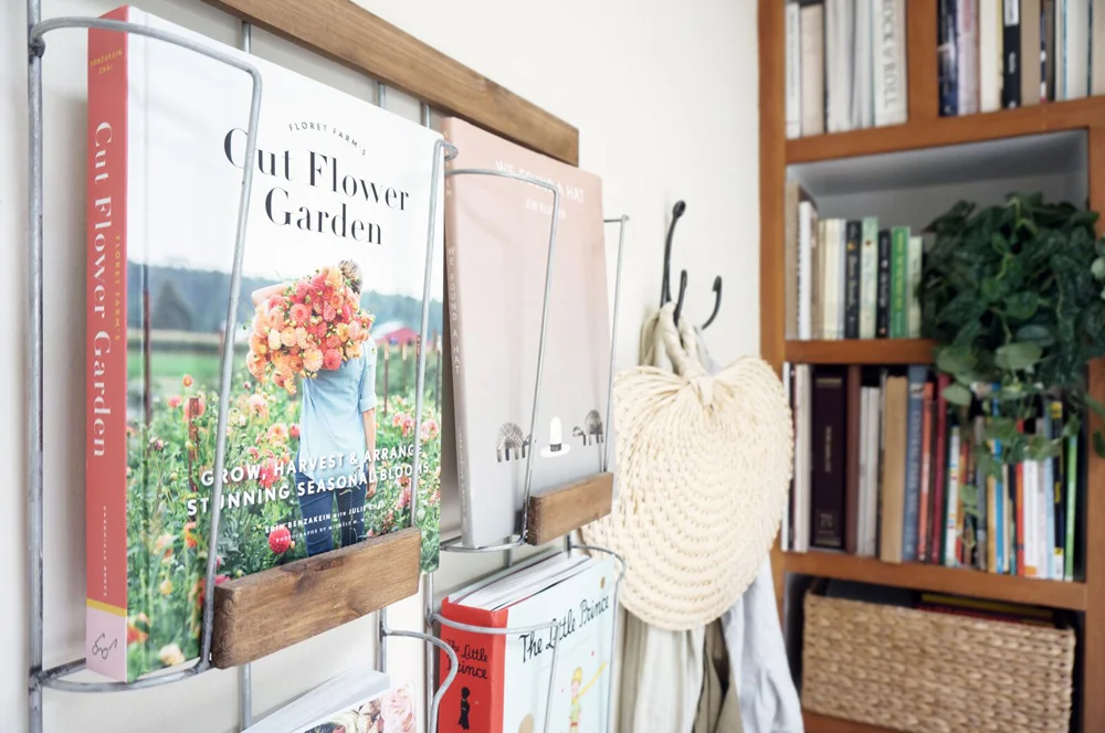 Above: The back tiny cottage: A wood + wire bookshelf mounted on the wall displays books as art.