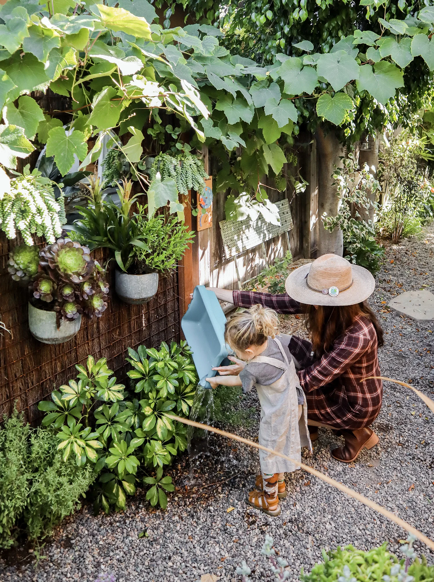 Giving the cottage plants a bath with the leftover water from West’s activity table.