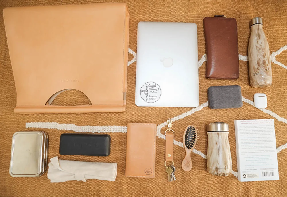 My handbag necessities for home or travel, including a Nimble wireless charging kit (made from a sustainable blend of recycled water bottles & organic hemp), bamboo cutlery, reusable bottles, stainless steel to-go food containers, and more.