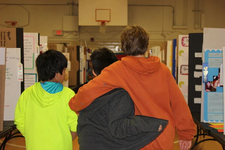 A scene from Science Fair Week at Cunningham Elementary: compassion in action. (Photo by Dawn Johnson.)